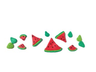 Delicious red watermelon slice and green leaf made from plasticine clay decorate are beautiful line horizontal on white background, cute fruit shape dough