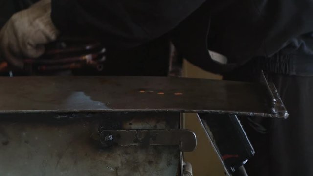 The working specialist prepares equipment for hardening and heat treatment of metal parts by heating, close-up, industry, workshop