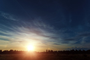 Beautiful foggy landscape, sunset. The fog glowing in the sunlight, above the meadow grass.