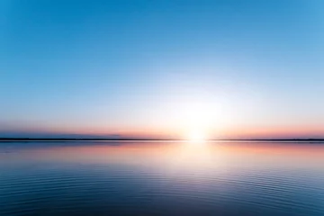 Fotobehang Ochtendgloren Mooie, rode dageraad op het meer. De stralen van de zon door de mist. De blauwe lucht boven het meer, de ochtend komt, de lucht wordt weerspiegeld in het water.