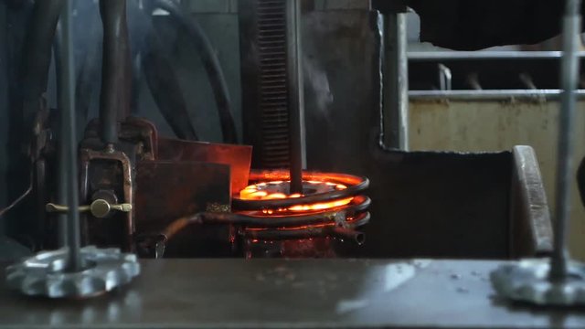 Hardening and heat treatment of the metal gear of the part on the equipment for hardening of metal products, heat treatment at the factory, close-up, harding