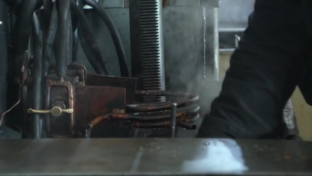 Hardening and heat treatment of the metal gear of the part on the equipment for hardening of metal products, heat treatment at the factory, close-up, industrial