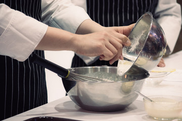 Closeup of hands mixing ingredients in a bowl, Pastry