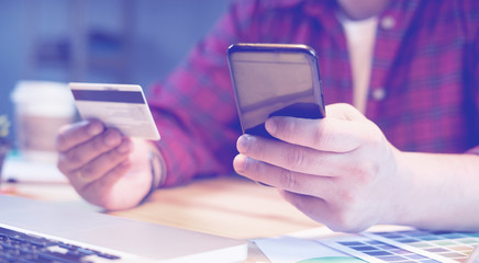 businessman using Credit card verifies account balance on mobile banking application.Online payment shopping,selective focus,vintage color,business concept