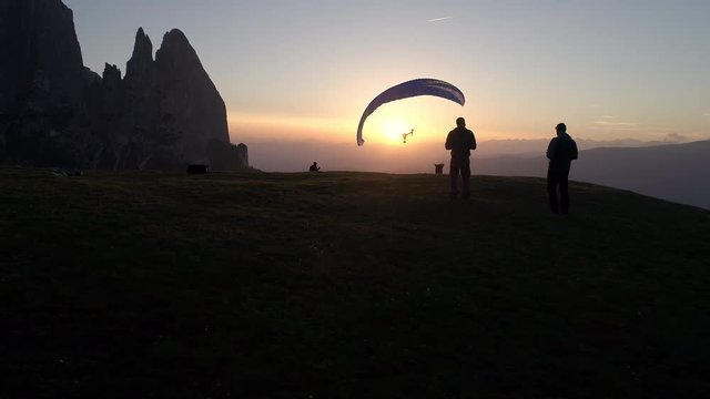 Aerial - Silhouette of two paragliders being followed by dual operator drone