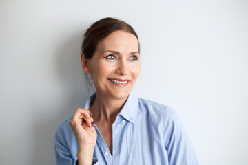 Obraz premium Beautiful mature woman smiling.Close up portrait of beautiful older woman smiling and standing by wall.Portrait of business woman with glasses smiling.