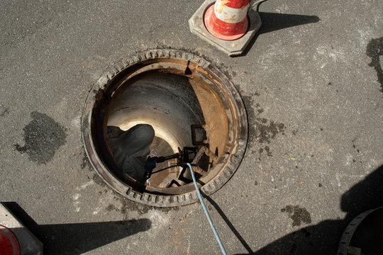 Wartung eines Kanalschachtes, entfernen mittels Bohrhammer von Steigeisen,  die zum Kanal hinab f&uuml;hren