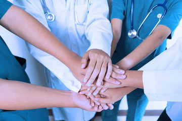 Doctors and nurses coordinate stacking hands together at hospital, Concept Teamwork, happy doctors working together as the team for motivation, success medical health care, blue tone color