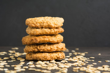 Stack of five homemade cookies of oat on dark background