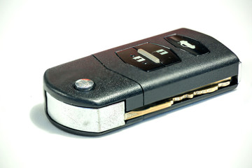 Old car key with remote control on white background, safety lock technology.