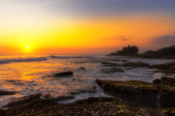 Obraz premium Pura Tanah Lot temple on the beach at sunset in seaside of Bali island. Shilouette of a temple