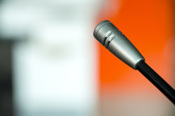 Microphone in concert hall or conference room soft and blur style for background.Microphone over the Abstract blurred photo of conference hall or seminar room background.
