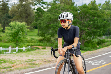 Cycling,A young cyclist sitting relax on a bicycle saddle after the race. Sports women bikes in the morning,vintage color,selective focus, sports concept,low angle view,Business competition