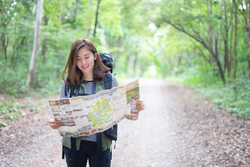 Hipster Asian young girl with backpack enjoying forest on mountain.Tourist traveler with trendy...