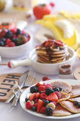 Pancakes served with many fresh fruits and berries