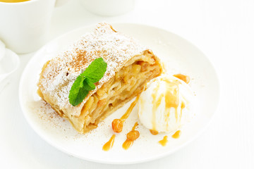 apple strudel with cinnamon and an ice cream ball.