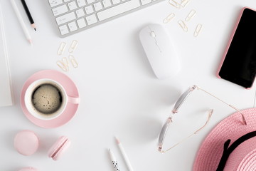 Trendy feminine home office workspace. White office desk. Laptop, coffee cup and macaroons, phone,...
