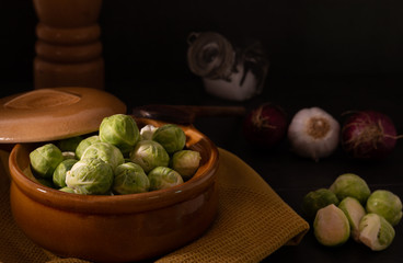 Organic raw Brussels sprouts on a kitchen table, selective lighting