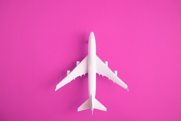 Airplane model. White plane on pink background. Travel vacation concept. Summer background. 