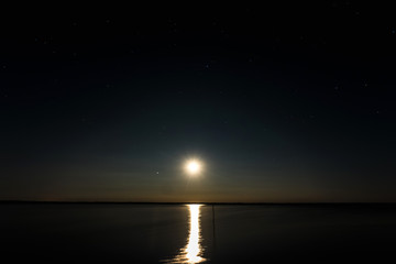 Night moon sky, full moon, Moon over the lake. Night landscape. Reflection of the rays from the moon in the water.