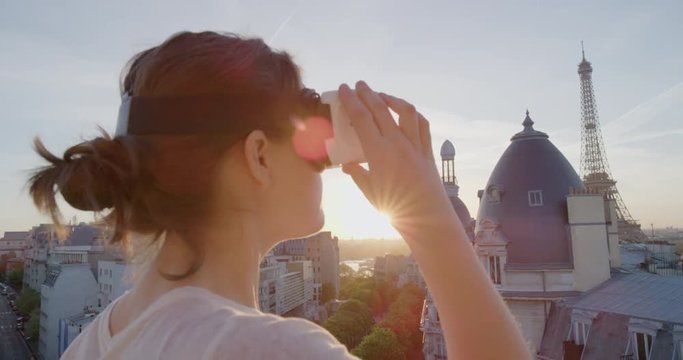 woman using virtual reality headset enjoying exploring online cyberspace experience on balcony in beautiful paris sunset close up