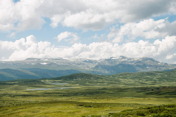 aerial view of green valley with mountains and cloudy sky, Hallingskarvet National park, Norway