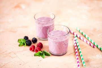 Delicious blackberry raspberry smoothie with mint and fresh berries in glasses. Selective focus.