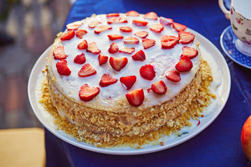 Homemade honey cake with layers and decorated with strawberries