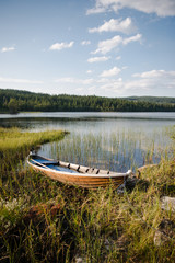 Wooden boat near lake in front of forest in Trysil, Norway's largest ski resort
