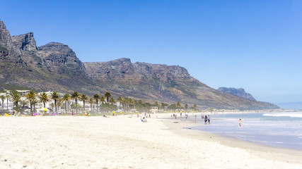 People and city at Camps Bay beach, Cape Town, South Africa