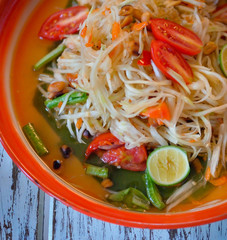 papaya salad, som tum on wooden background