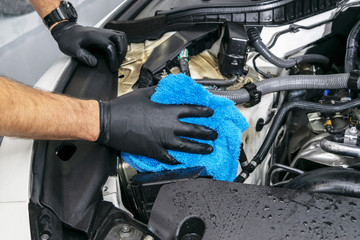 A man cleaning car with microfiber cloth. Car detailing. Valeting concept. Selective focus. Car detailing. Cleaning with sponge. Worker cleaning. Microfiber and cleaning solution to clean