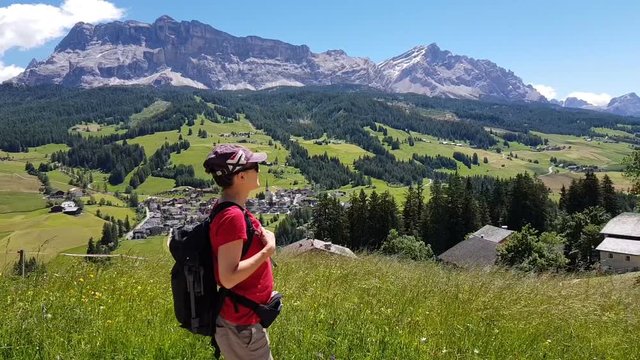 A woman with a backpack walking in the mountains, Dolomites, Italy