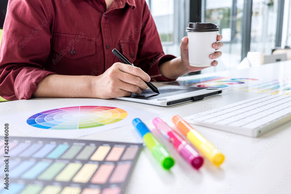 Poster Image of female creative graphic designer working on color selection and drawing on graphics tablet at workplace