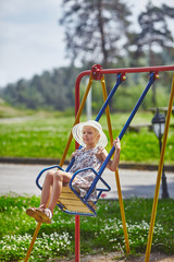 Cute girl swinging on teeter-totter at kids playground