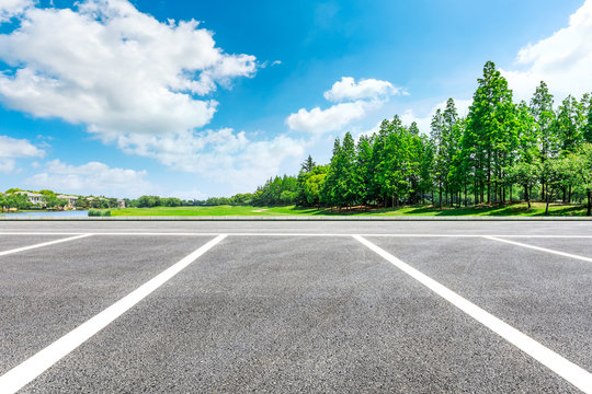 Asphalt road and woods with apartment buildings in the city suburbs
