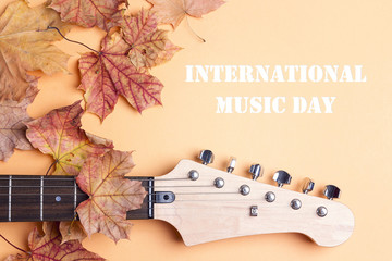 International Music Day background with electric guitar neck and autumn maple leaves.