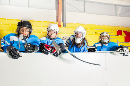 School hockey team sitting on the bench near arena