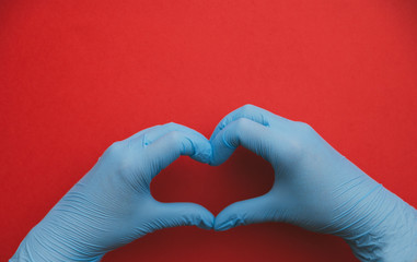 Fototapeta premium isolated hands in blue gloves with heart sign, love