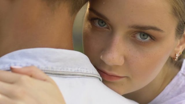 Young lady hugging man, looking at camera, contraception, social advertisement