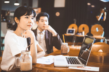Young businessman and businesswoman having a meeting in cafe.