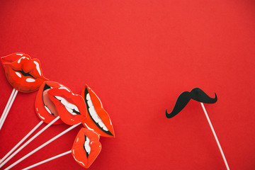 flatlay overhead top black paper photo booth props emotions lip and mustache red background copy space © Наталья Маяк