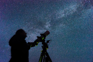 Silhouette of a woman with a telescope