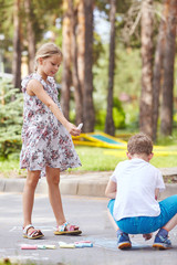Girl sharing with boy her chalk, friendship and kindness concept