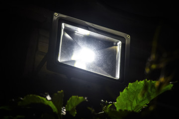 Garden LED spotlight on a wooden building close-up.