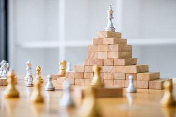 Chess leadership and success concept, chess save the strategy and king on chess board and wooden game tower