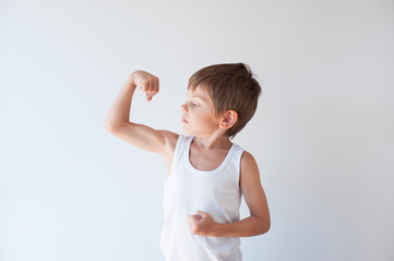 cute healthy little kid in white shirt showing his biceps muscle