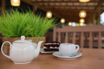 Kettle with a drink and dessert in a street cafe. Tea in the ket