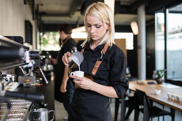 Young woman at barista school learning how to make espresso coffee. - obrazy, fototapety, plakaty