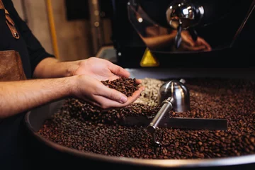 Foto op Plexiglas Close up shot of male hands holding roasted coffee beans. © hedgehog94
